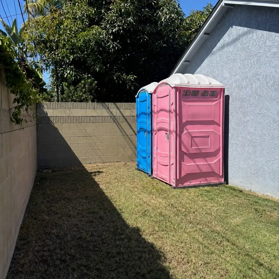Porta potties on the lawn beside a house