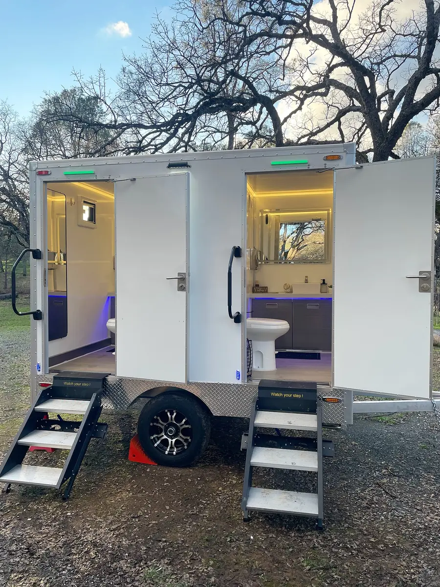 Restroom trailer with interior lights at dusk